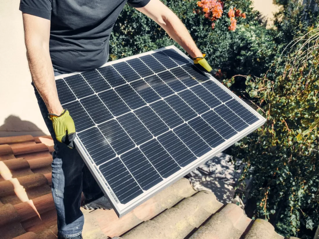 Solar installer fitting a panel on a roof